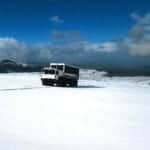 A white truck driving across a snowy field during a Regent Seven Seas Cruises expedition.