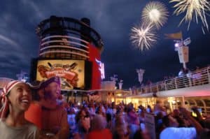 A group of people watching fireworks on a Disney cruise ship departing from Galveston.