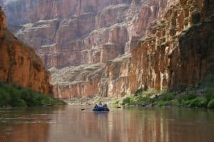 A group of people are paddling down the grand canyon during USA Tours.
