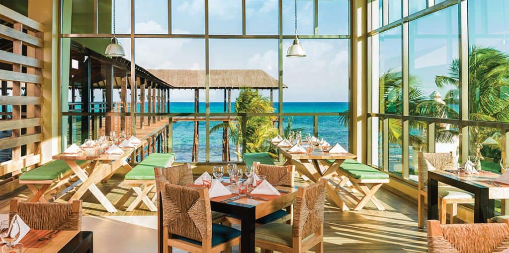 A wedding venue with large windows overlooking the ocean.