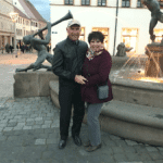 A couple standing in front of a European river cruise ship fountain.