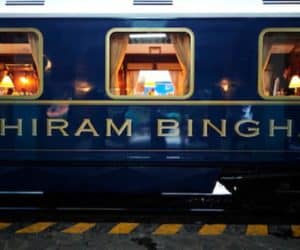 A vibrant blue train offering a delightful vacation by train experience with the captivating "thiram bhingh" inscription.