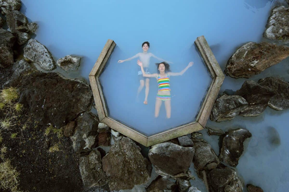 Two people enjoying Adventures by Disney in the blue lagoon in Iceland.