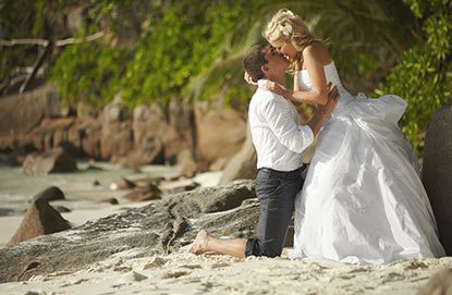 A bride and groom sharing a romantic kiss on the beach during their dreamy Fox Travel destination wedding.