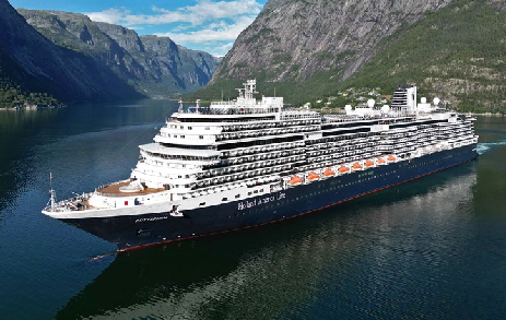 A large cruise ship sails through a scenic fjord with steep mountains and a blue sky in the background, while passengers hope for a glimpse of the majestic Northern Lights.