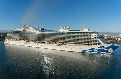 British Isles Cruise Majestic Princess from Foc Travel Agency The Woodlands sails on calm blue water near a coastal city, with multiple decks and smoke drifting from the funnel.