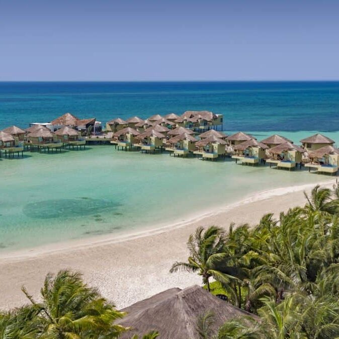 An aerial view of a beach resort with Karisma Overwater Bungalows.